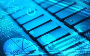 Un primer plano de un teclado de computadora con superposición de gráficos digitales, que incluye gráficos, un mapa del mundo e íconos tecnológicos en un esquema de color azul.